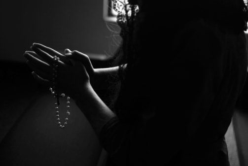 ženske, ki molijo v temi s Svetim pismom