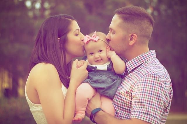 billede af familien, der kysser barnet, der symboliserer forholdet